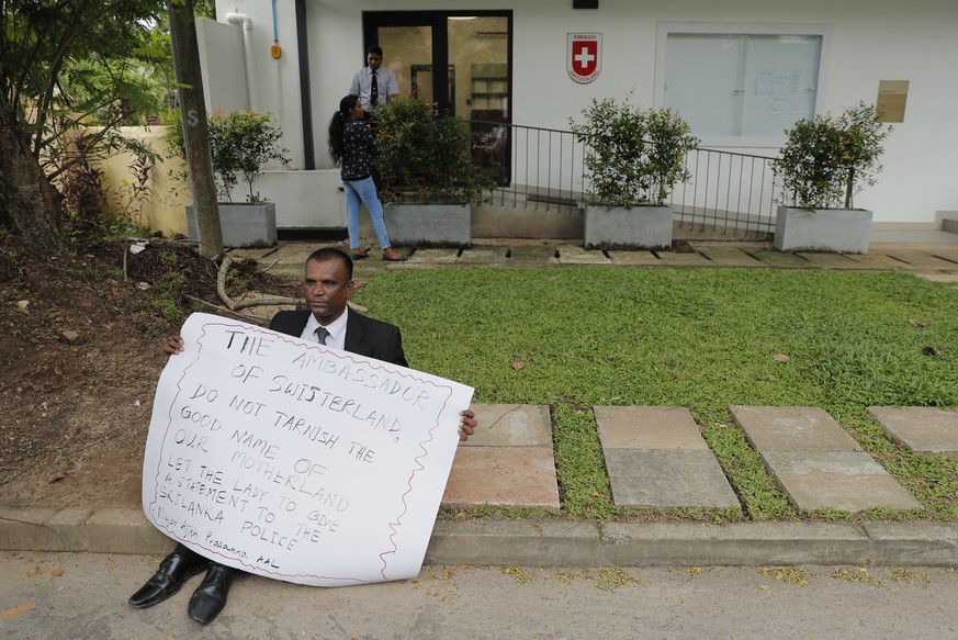Sri Lankan retired military officer Ajith Prasanna protests outside the Swiss Embassy demanding the questioning of its employee in Colombo, Sri Lanka, Monday, Dec. 2, 2019. Sri Lankan authorities have ...