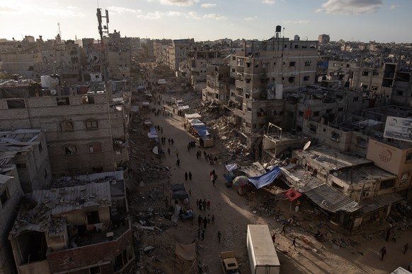 epa11342789 A general view shows Palestinians walking at newly opened market inside the Khan Yunis camp next to the ruins of their destroyed homes, after the Israeli army asked them to evacuate from t ...