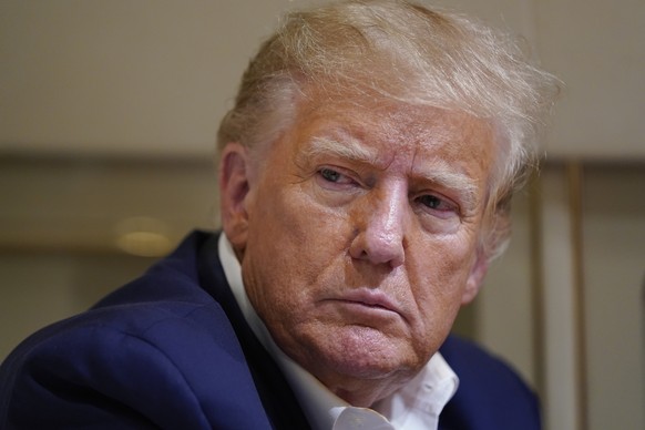 FILE - Former President Donald Trump listens as he speaks with reporters while in flight on his plane after a campaign rally at Waco Regional Airport, in Waco, Texas, March 25, 2023, while en route to ...