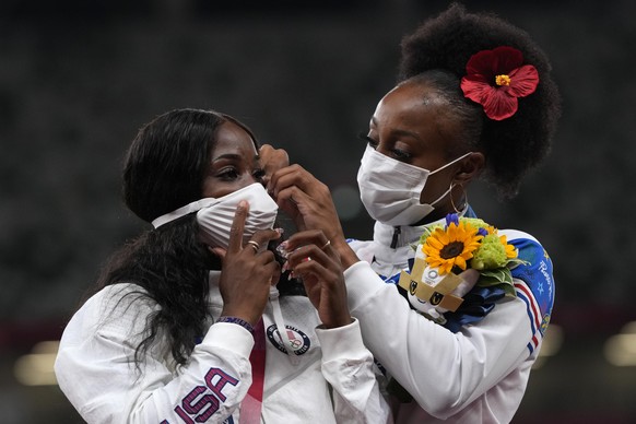 Gold medalist Jasmine Camacho-Quinn, of Puerto Rico, right, adjusts the mask of silver medalist Kendra Harrison, left, of the United States after winning the women&#039;s 100-meters hurdles at the 202 ...