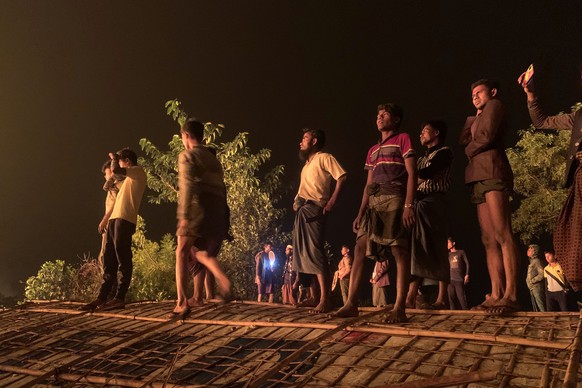 Rohingya refugees watch a fire burning in their refugee camp in Kutupalong in Cox's Bazar district, Bangladesh on Sunday, January 7, 2024.  (AP Photo/Shafiqur Rahman)