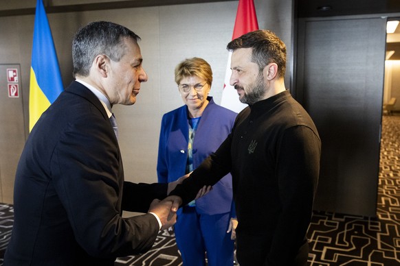 epa11411677 Swiss Federal Councillor Ignazio Cassis (L) and Ukraine&#039;s President Volodymyr Zelensky (R) shake hands next to Swiss Federal President Viola Amherd (C) during the Summit on Peace in U ...