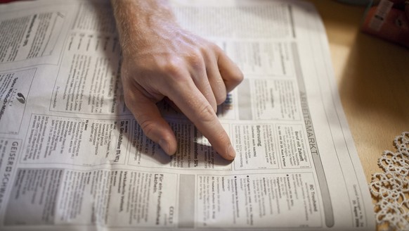 Unemployed Dominik G. looks for suitable job ads in the newspaper, pictured on August 21, 2009 in the canton of Aargau, Switzerland. (KEYSTONE/Gaetan Bally)

Der arbeitslose Dominik G. sucht in der Ze ...