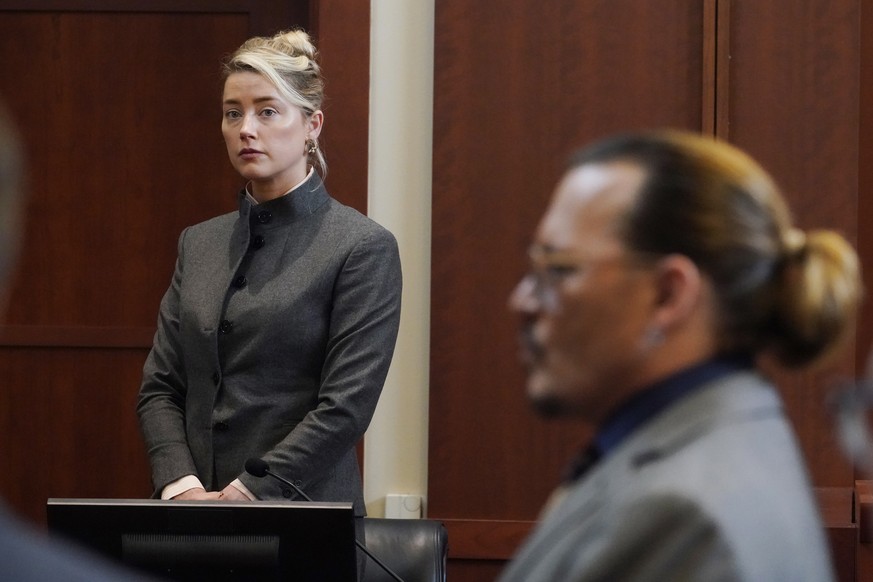 FILE - Actors Amber Heard and Johnny Depp watch as the jury leaves the courtroom for a lunch break at the Fairfax County Circuit Courthouse in Fairfax, Va., Monday, May 16, 2022. Heard notified a Virg ...