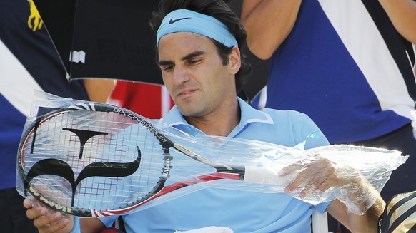 Roger Federer of Switzerland takes a fresh racket out of its bag during a break between sets as Federer plays Paul-Henri Mathieu of France at the U.S. Open tennis tournament in New York, Saturday, Sep ...