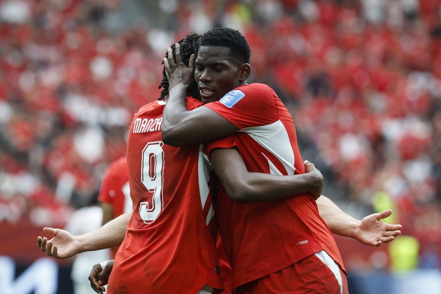 Switzerland's Johan Manzambi celebrates with teammate Breel Embolo after scoring the second goal during the World Cup Group B soccer match between Switzerland and Canada at the BC Place stadium i ...