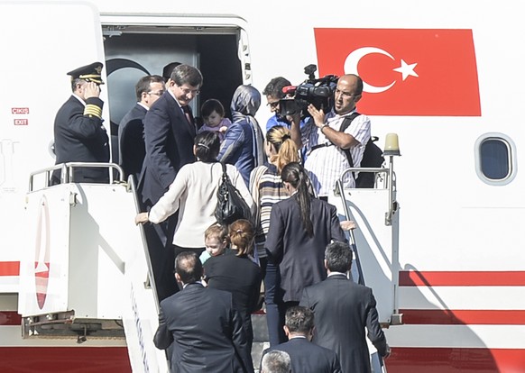 Der türkische Ministerpräsident Ahmet Davutoglu besteigt in der südtürkischen Stadt Sanliurfa zusammen mit den befreiten Geiseln ein Flugzeug Richtung Ankara (20.09.2014).