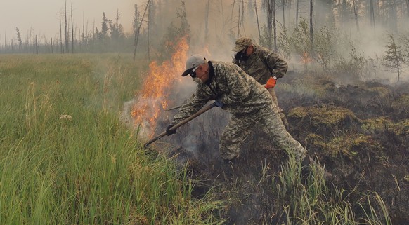 Volunteers douse a forest fire in the republic of Sakha also known as Yakutia, Russia Far East, Saturday, July 17, 2021. Russia has been plagued by widespread forest fires, blamed on unusually high te ...