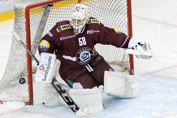Geneve-Servette&#039;s goaltender Jussi Olkinuora turns away the puck, during a National League regular season game of the Swiss Championship between Geneve-Servette HC and EV Zug, at the ice stadium  ...