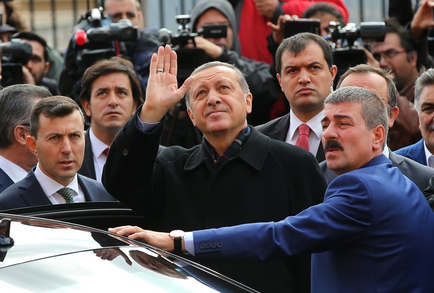 Turkey&#039;s President Recep Tayyip Erdogan, center, escorted by his bodyguards waves to his supporters after he casts his vote outside a polling station, in Istanbul, Sunday, Nov. 1, 2015. Turks hea ...