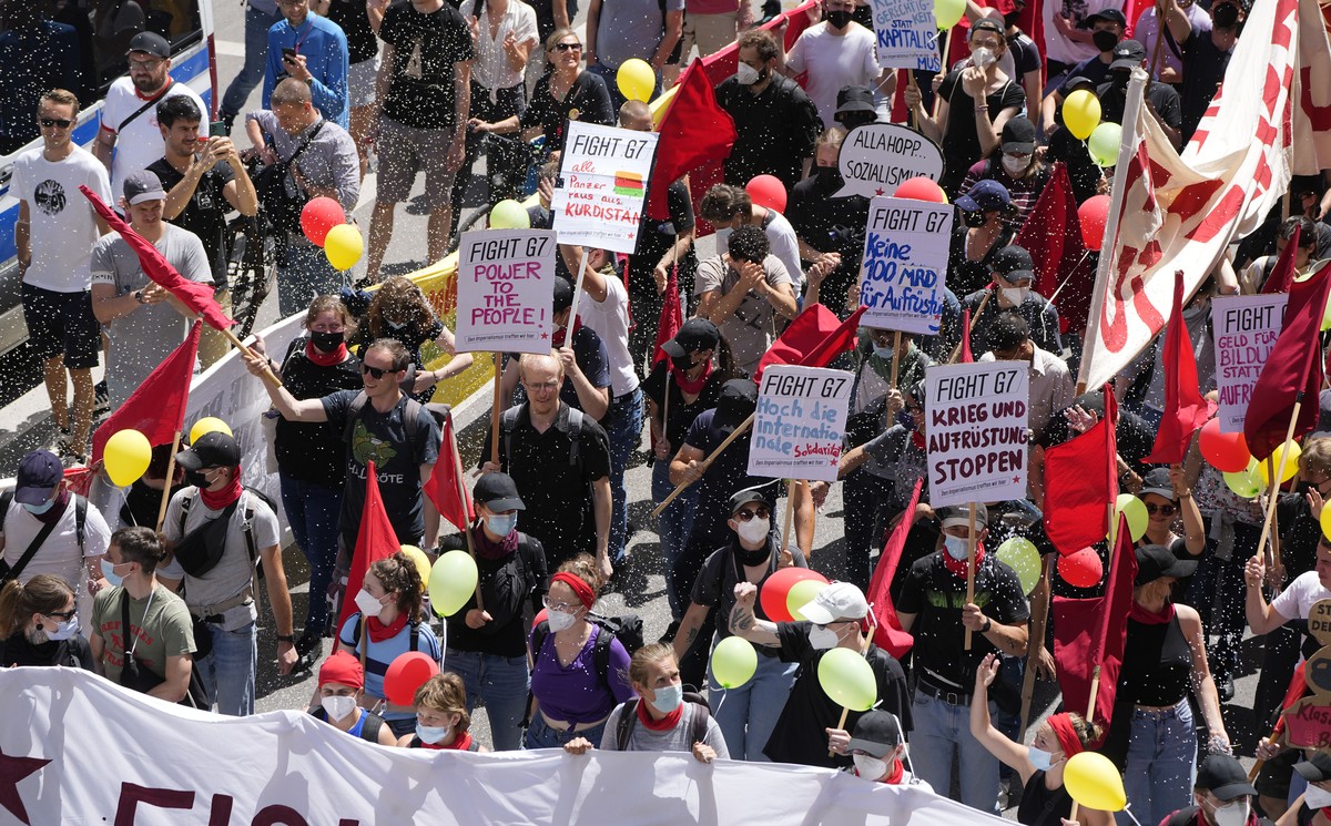 Activists hold banners and signs as confetti falls during a demonstration ahead of the G7 meeting in Munich, Germany, Saturday, June 25, 2022. The G7 Summit will take place at Castle Elmau near Garmis ...