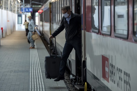 Reisende bei der Ankunft am Bahnhof SBB in Basel, am Montag, 6. Juli 2020. Das Schutzkonzept gegen das Coronavirus wurde angepasst: Alle Reisenden muessen in oeffentlichen Verkehrsmitteln eine Maske t ...