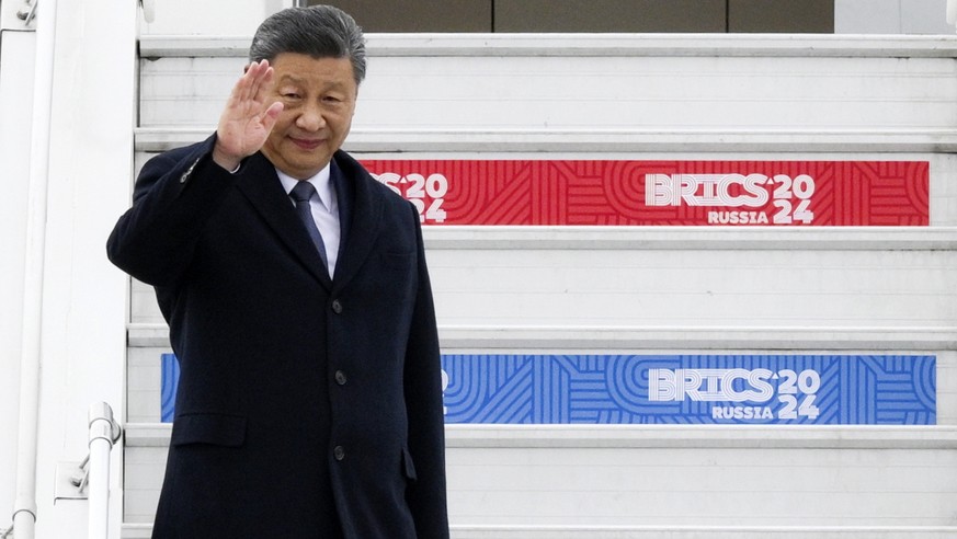 epa11674413 A handout photo made available by photo host brics-russia2024.ru that shows Chinese President Xi Jinping waving as he arrives at Kazan International Airport prior to the BRICS summit in Ka ...