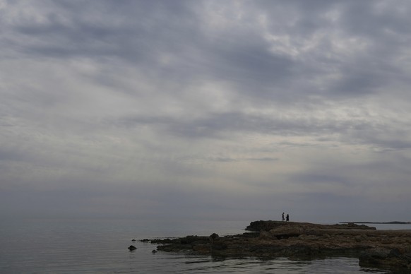 People walk on the rocks at the sea as dust cover the sky during a hot day in Ayia Napa resort, in the easter Mediterranean island of Cyprus, Monday, March 17, 2025. (AP Photo/Petros Karadjias)
Cyprus ...