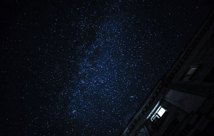 epa10277581 A lighted window and a night sky bright with stars seen as the street lights are switched off in Mykolaiv, Ukraine, 31 October 2022. Scheduled power cuts were introduced in Kyiv, power ope ...