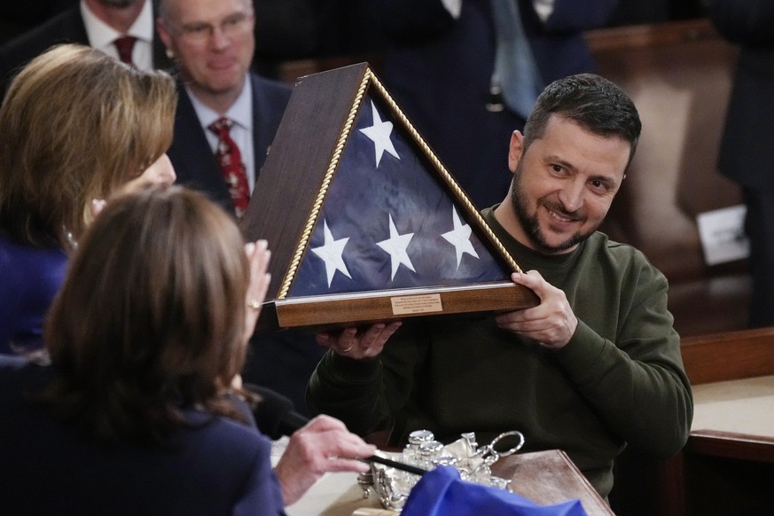Ukrainian President Volodymyr Zelenskyy holds an American flag gifted to him by House Speaker Nancy Pelosi of California after addressing a joint session of Congress on Washington's Capitol Hill.