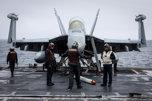 epa10303850 US Navy service members maintain an F-18 fighter jet on deck during Sunday break on the side of an exercise called Silent Wolverine on the USS Gerald R. Ford aircraft Carrier in Eastern At ...