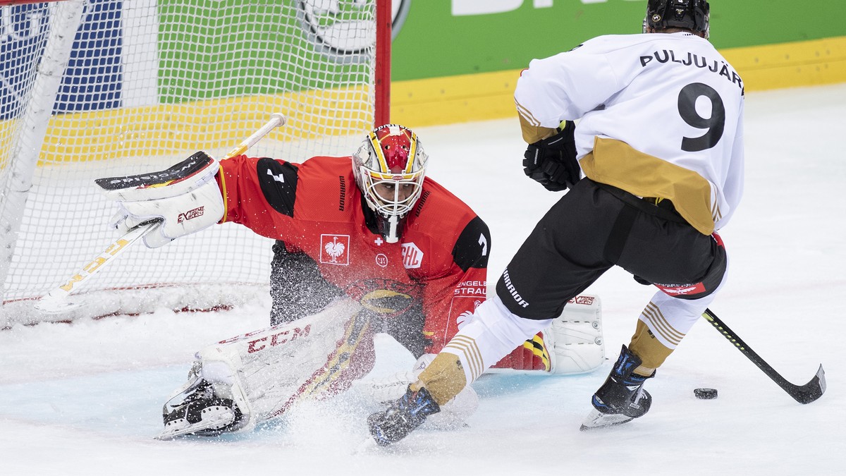 BernÕs goaltender Niklas Schlegel, left, fights for the puck with OuluÕs Jesse Puljujaervi, right, during the Champions Hockey League round of 4 match between Switzerland's SC Bern and FinlandÕs  ...