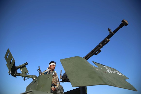 epa09195866 An Afghan security official stands guard as people celebrate the Eid al-Fitr, which marks the end of Ramadan, in Jalalabad, Afghanistan, 13 May 2021. The Taliban on 10 May, announced a thr ...