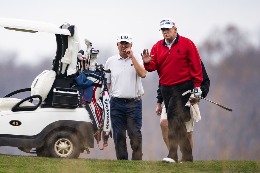 epaselect epa08834479 US President Donald J. Trump (R) plays golf for the 143rd time since becoming president at the Trump National Golf Club in Sterling, Virginia, USA, 21 November 2020. The presiden ...