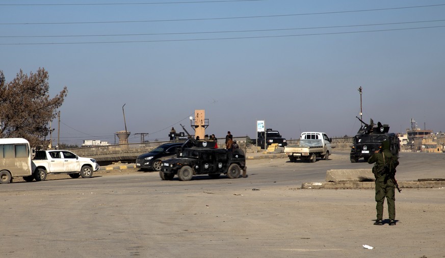 epa09700824 Fighters of Syria democratic forces (SDF) take up position at Ghweran district in Hasaka, northeastern Syria, 21 January 2022. According to the Syrian Observatory for Human Rights, at leas ...