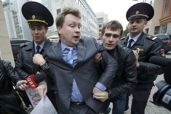 FILE - In this Sept. 25, 2013, file photo, police detain Russia&#039;s leading gay rights campaigner Nikolai Alexeyev, center, during a protest outside the Sochi 2014 Winter Olympic Games organizing c ...