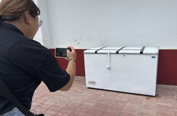 A Thai reporter takes a photo of an empty freezer at the Nong Prue police station in Pattaya, Chonburi province, Thailand, Tuesday, July 11, 2023. The dismembered body of a 62-year-old German business ...