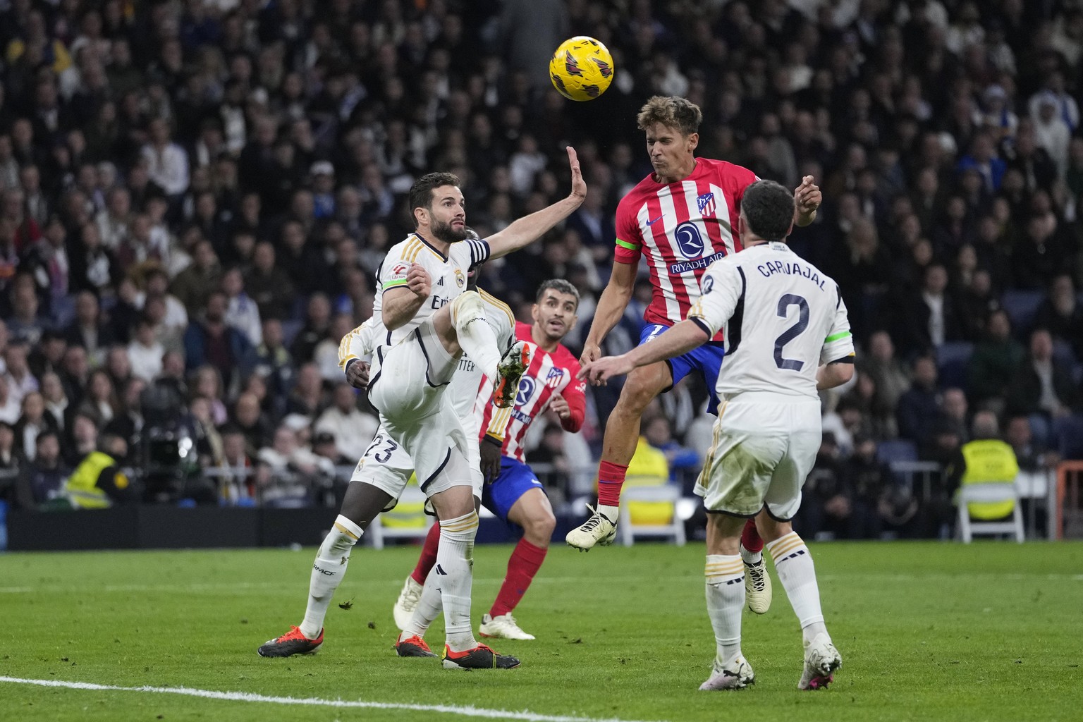 Atletico Madrid&#039;s Marcos Llorente, top right, scores his side&#039;s first goal during the Spanish La Liga soccer match between Real Madrid and Atletico Madrid at the Santiago Bernabeu stadium in ...