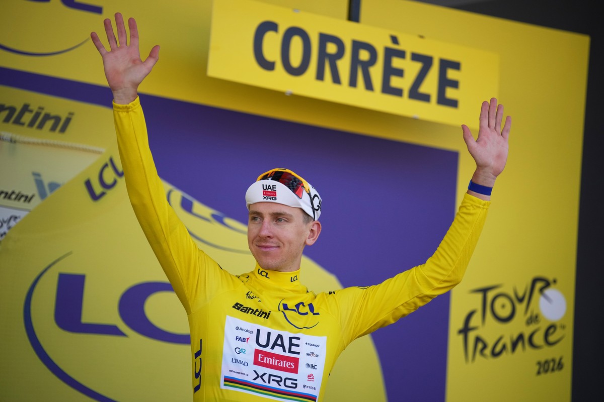Slovenia's Tadej Pogacar, wearing the overall leader's yellow jersey, celebrates on the podium after the ninth stage of the Tour de France cycling race with start in Malemort and finish in U ...