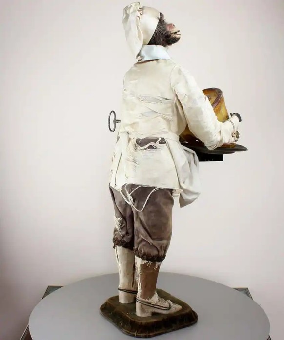 19th century automaton of a monkey pastry-chef, who serves the severed head of an equally creepy cat in a pastry pie.
It was made by the renowned French toy-makers Roullet &amp; Decamps, around 1880.