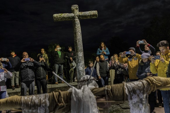 Villagers take snapshots of a penitent during the Catholic procession of &#039;Los Empalaos&#039; in Valverde de la Vera, southwest Spain, early Friday, April 19, 2019. Hundreds of processions take pl ...