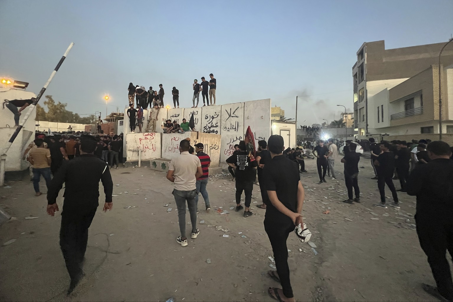 Protesters scale a wall at the Swedish embassy in Baghdad on Thursday, July 20, 2023. Protesters angered by the burning of a copy of the Quran stormed the embassy early Thursday morning and broke into the complex…
