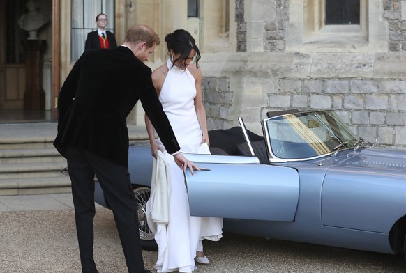 The newly married Duke and Duchess of Sussex, Meghan Markle and Prince Harry, prepare to leave Windsor Castle in a convertible car after their wedding in Windsor, England, to attend an evening recepti ...