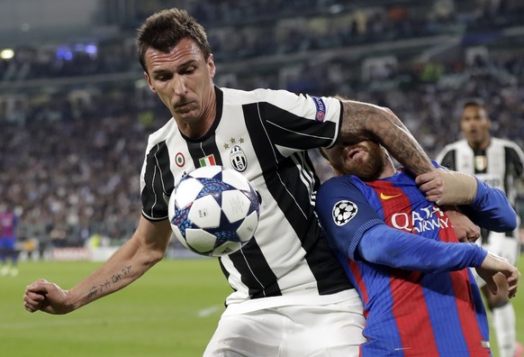 Juventus&#039;s Mario Mandzukic, left, and Barcelona&#039;s Lionel Messi vie for the ball during a Champions League, quarterfinal, first-leg soccer match between Juventus and Barcelona, at the Juventu ...