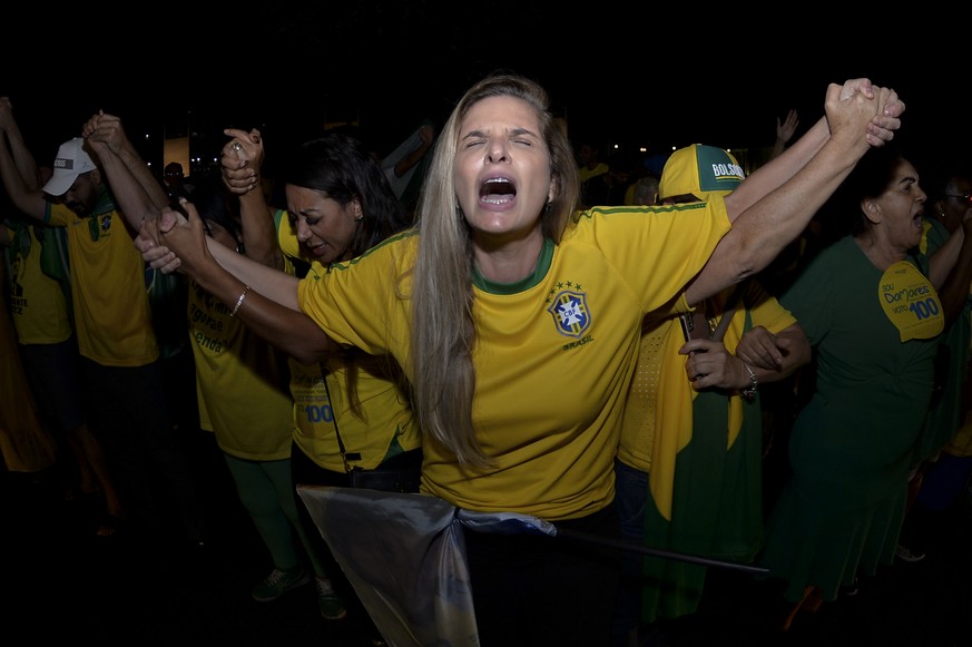 Supporters of Brazilian President Jair Bolsonaro, who is running for another term, pray as they wait for the results after general election polls closed in Brasilia, Brazil, Sunday, Oct. 2, 2022. (AP  ...