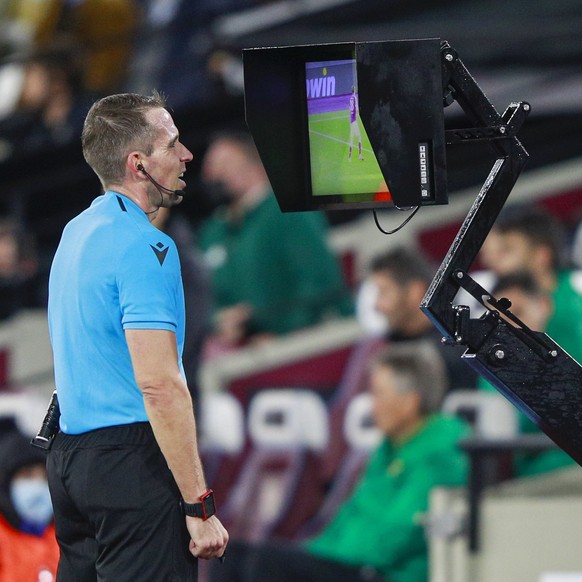 Referee Tobias Stieler checks VAR during the Europa League Group H soccer match between West Ham and Rapid Vienna at London Stadium in London, Thursday, Sept. 30, 2021. (AP Photo/Ian Walton)