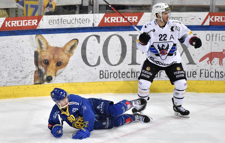 Der Fribourger Jim Slater (USA), rechts, hat den Davoser Sven Jung gefaellt, beim Eishockey Meisterschaftsspiel in der Qualifikation der National League zwischen dem HC Davos und dem HC Fribourg-Gotte ...