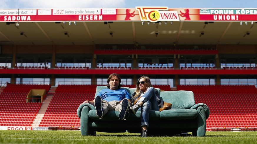 Torsten and Sylvia sit on their sofas after setting them up on the pitch of the Alte Foersterei stadium for World Cup 2014 public viewing events in Berlin June 1, 2014. The Union Berlin soccer club in ...