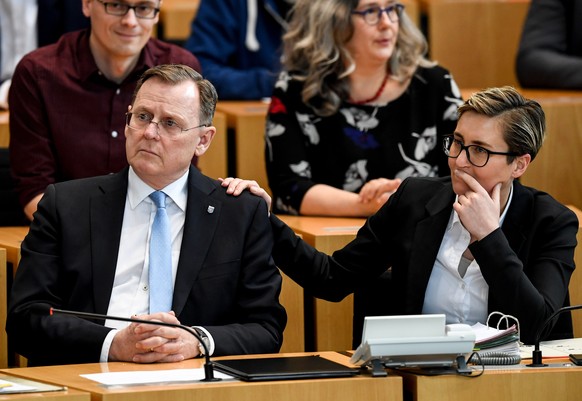 epa08269619 Candidate of The Left (Die Linke) party for the state elections Bodo Ramelow (L) and Susanne Hennig-Wellsow (R) react after the election of a new state prime minister of Thuringia in state ...