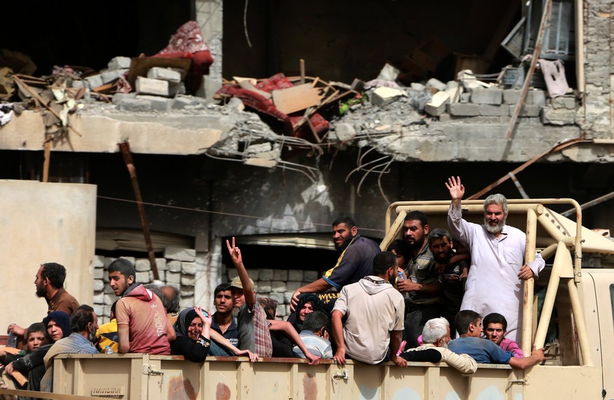 epa05975094 People board a truck as they flee from western Mosul, Iraq, 19 May 2017. Nearly 90 percent of west Mosul has been recaptured by Iraqi forces, and the Islamic State group in the city are on ...