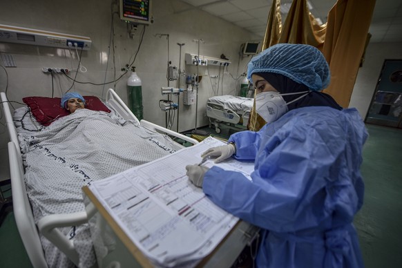 epa09500976 A member of the clinical staff wearing Personal Protective Equipment (PPE) cares for a patient with COVID-19 in the intensive care unit at the Al-Nasser Hospital in Khan Younis, southern G ...