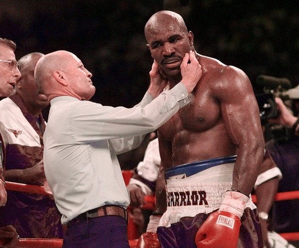 Evander Holyfield has his right ear checked by referee Mills Lane after he was bit in the ear by Mike Tyson in the third round of their WBA Heavyweight match Saturday, June 28, 1997, at the MGM Grand  ...