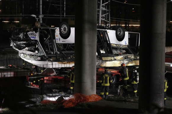 Italian firefighters work at the scene of a passenger bus accident in Mestre, near Venice, Italy, Wednesday, Oct. 4, 2023. According to local media, the bus fell a few meters from an elevated road bef ...