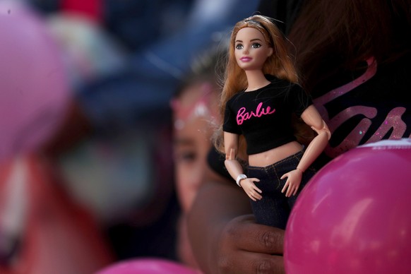 epa10763208 A person holds a Barbie doll during an event for the film &#039;Barbie&#039;, in La Paz, Bolivia, 22 July 2023. A &#039;pink tide&#039; began in the Plaza Bolivia to walk together to the c ...