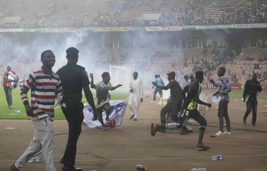 Police fire tear gas to chase pitch invaders at the end of Ghana and Nigeria 2022 Qatar World Cup qualifying playoff second leg soccer match, at Moshood Abiola Stadium, in Abuja, Nigeria, Tuesday, Mar ...