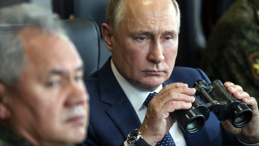 FILE - Russian President Vladimir Putin, right, holds a binoculars as Russian Defense Minister Sergei Shoigu sits near watching the joint strategic exercise of the armed forces of the Russian Federati ...