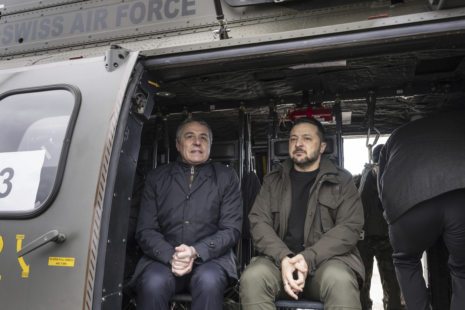 Swiss Foreign Minister Ignazio Cassis, left, and Ukrainian President Volodymyr Zelenskyy sit in a Swiss Air Force helicopter after Zelenskyy's arrival in Zu...