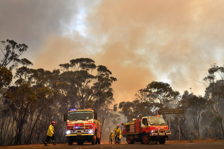 epa08076204 New South Wales (NSW) Rural Fire Service (RFS) and Fire and Rescue NSW crews work to contain the Gospers Mountain fire along the Bells Line of Road in the Blue Mountains National Park, nor ...
