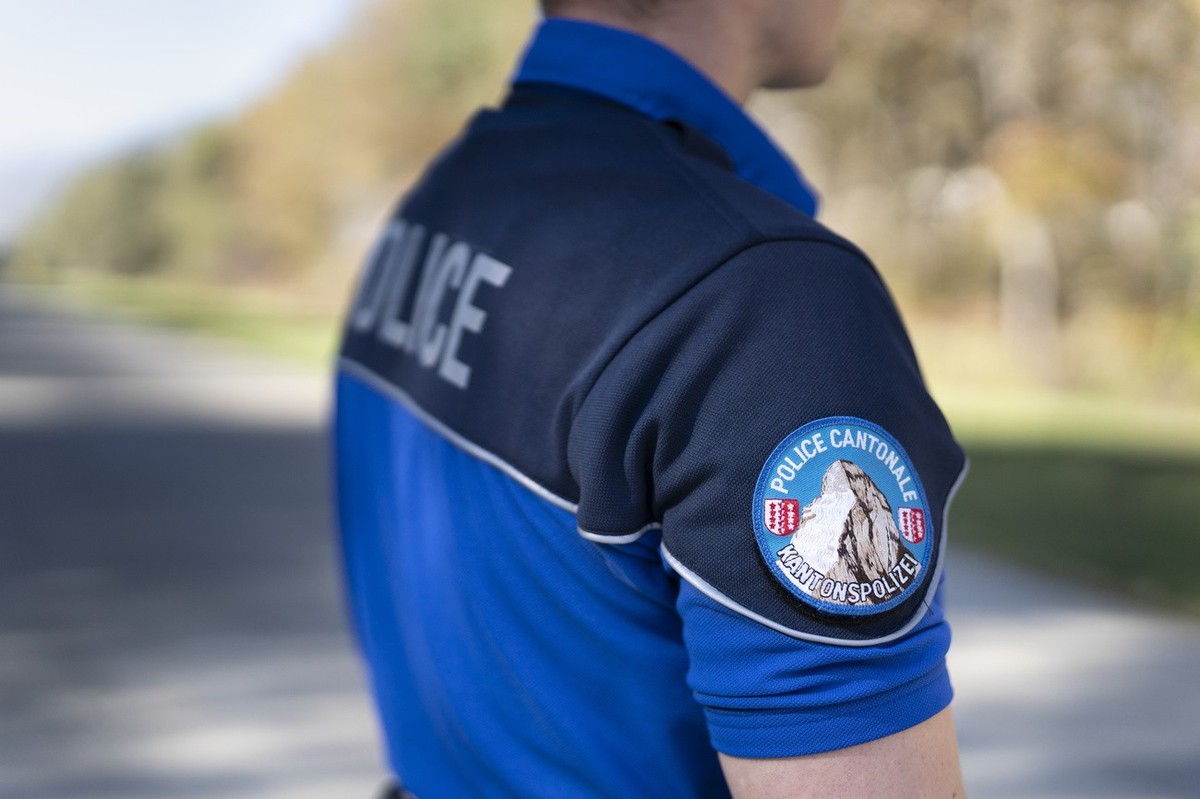 [Editor's note: photo mise-en-scene] Ein Polizist der Walliser Kantonspolizei fotografiert am 27. Oktober 2021 in Raron, Wallis. (KEYSTONE/Gaetan Bally)