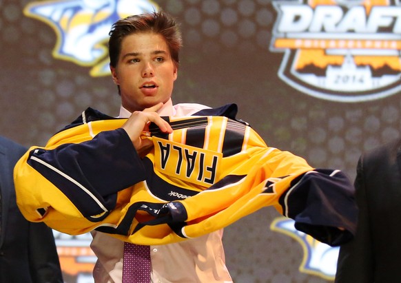 Jun 27, 2014; Philadelphia, PA, USA; Kevin Fiala puts on a team sweater after being selected as the number eleven overall pick to the Nashville Predators in the first round of the 2014 NHL Draft at We ...
